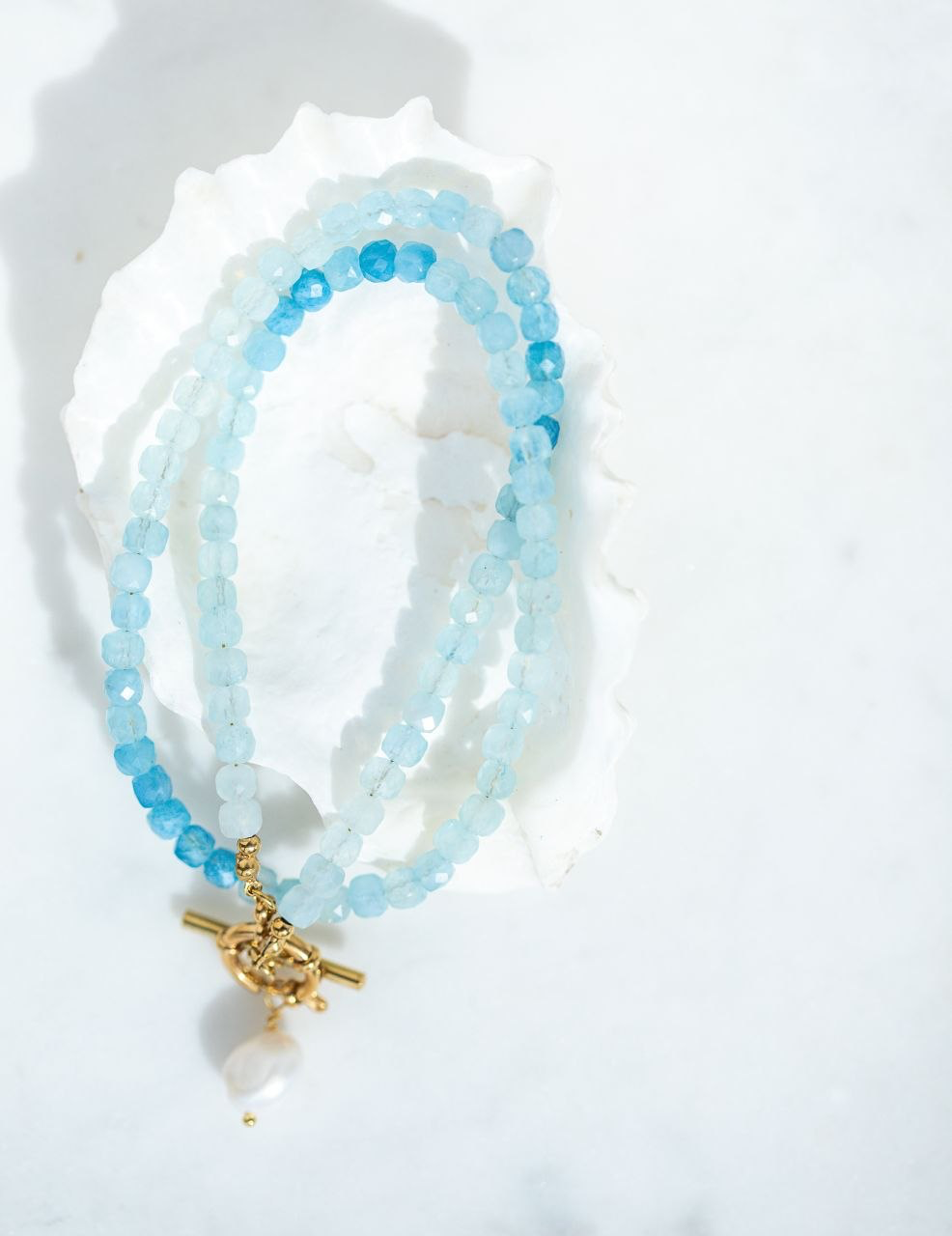 The Ombre Aquamarine Necklace with faceted cube aquamarine beads in soft,