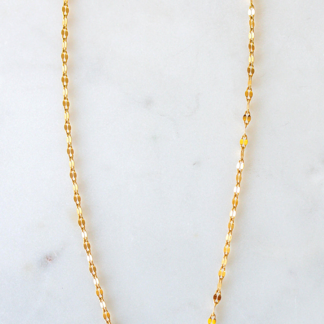 sparkly gold chain necklace on a white backdrop 
