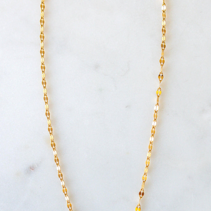 sparkly gold chain necklace on a white backdrop 