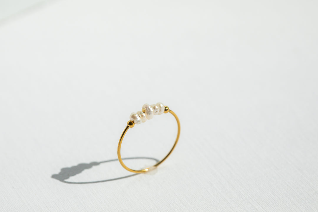 Gold ring with pearls on a white background