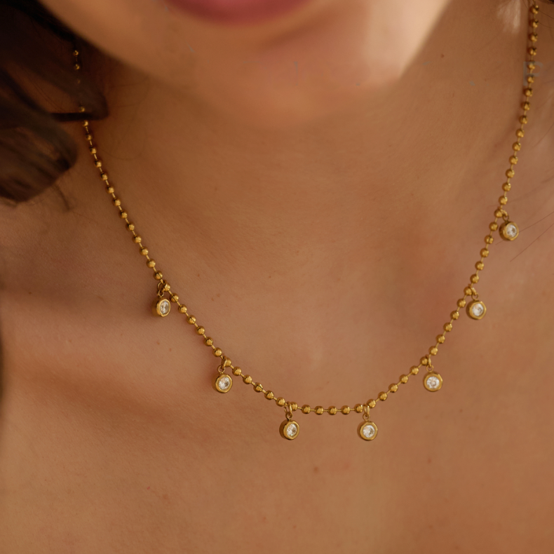 Gold necklace with small pearls on a person's neck