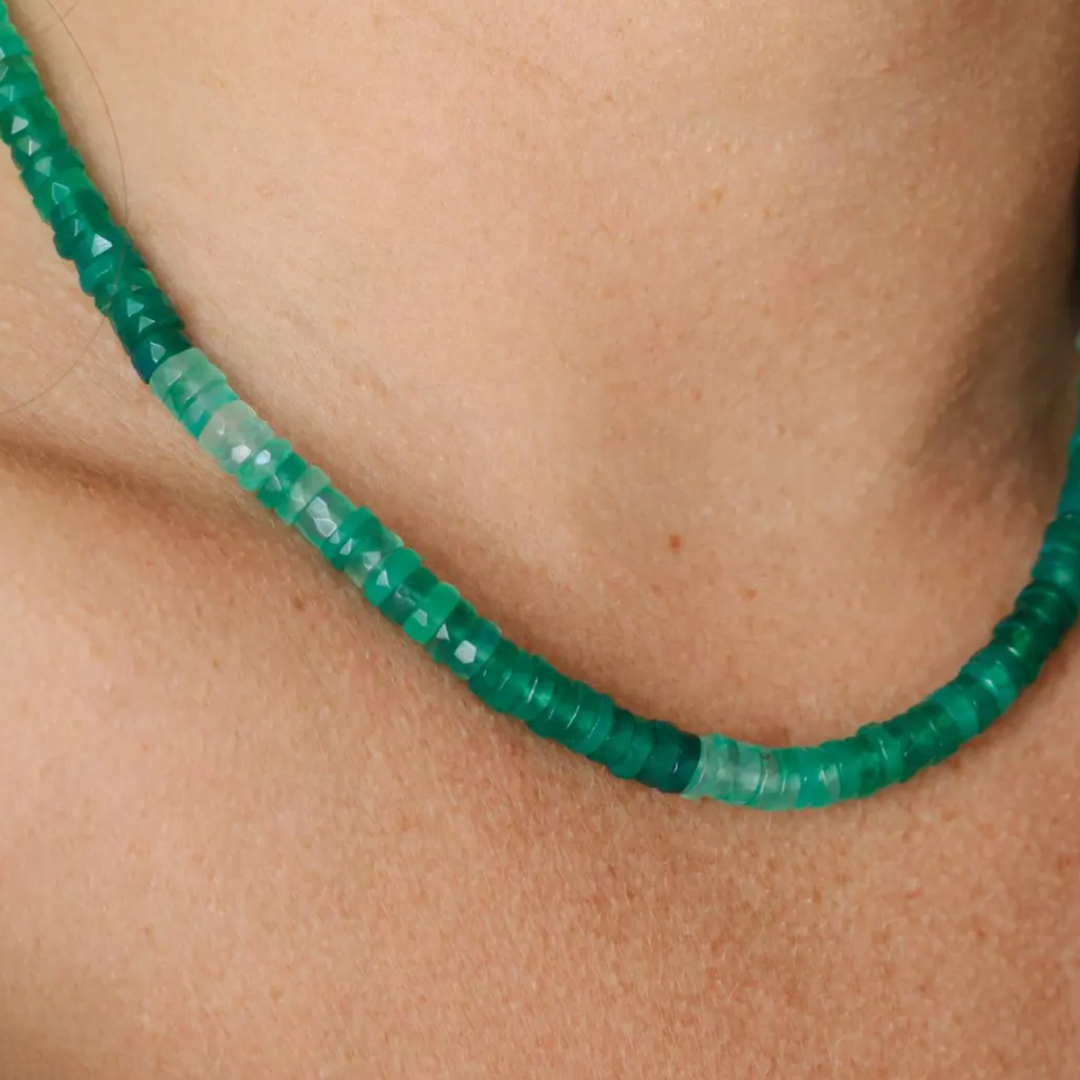 Close-up of a green beaded necklace on a person's neck