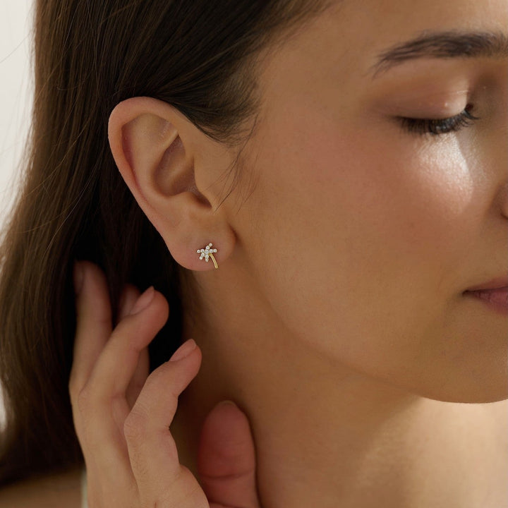 Close-up of a woman wearing dainty palm tree stud earrings tropical vacation jewelry 