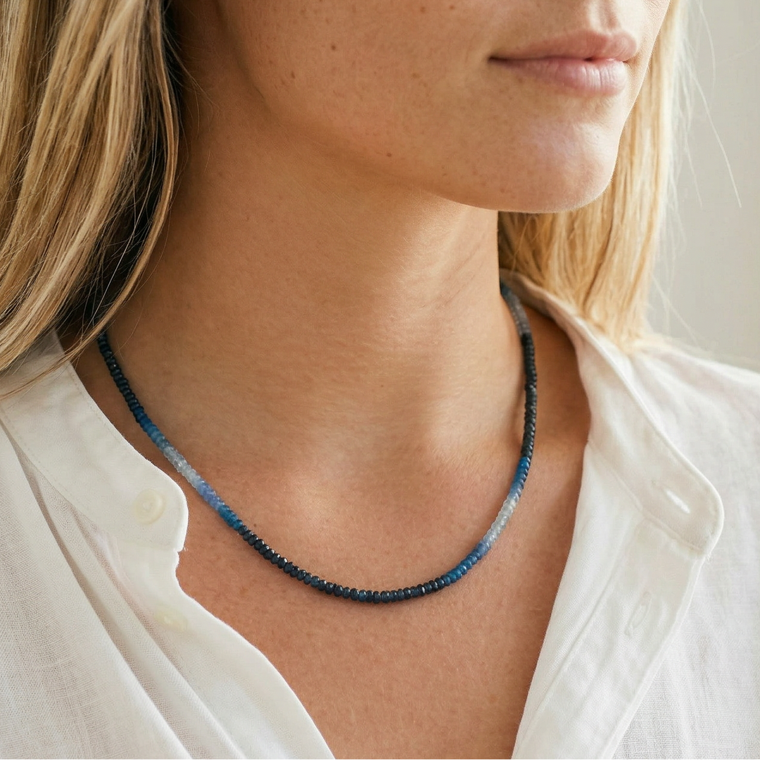 Woman wearing a blue AAA Sapphire beaded necklace against a neutral background