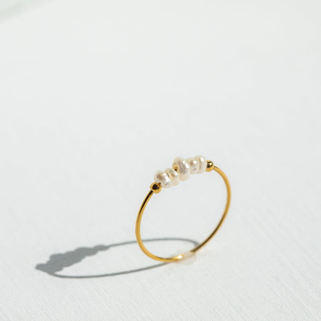 Gold ring with pearls on a white background