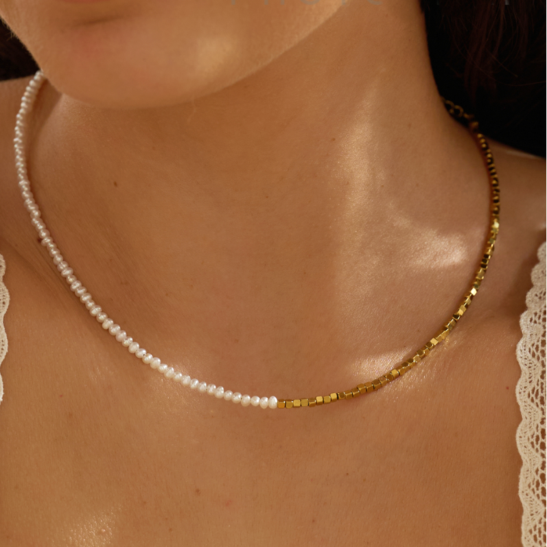 Pearl necklace on a person's neck with a blurred background