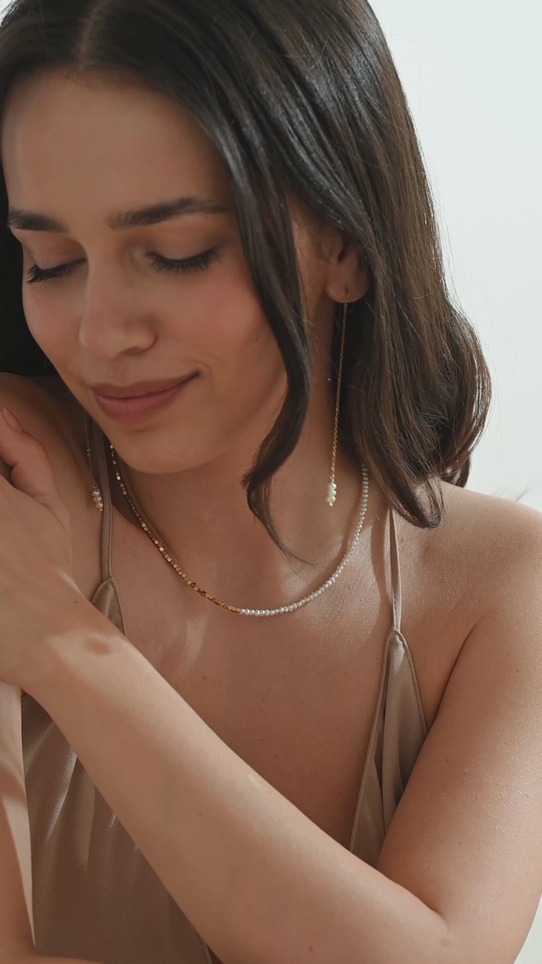 beautiful model wearing dainty pearl necklace with gold pearl threader earrings delicate and waterproof jewelry set 