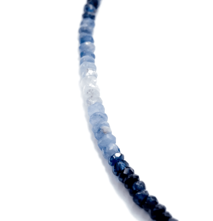 Close-up of a necklace with blue and white beads on a white background