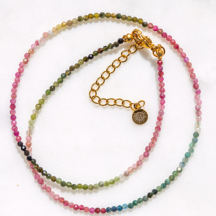 Multicolored beaded watermelon tourmaline gemstone necklace with a waterproof gold clasp on a white background