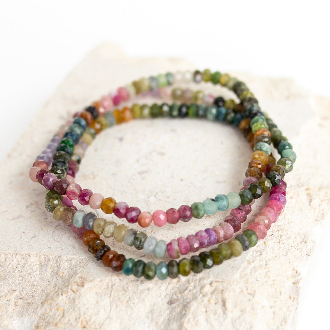 Set of multicolored watermelon tourmaline faceted  beaded bracelets on a textured surface